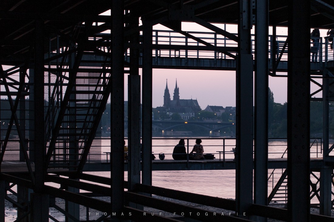 Sitzendes Paar auf dem Rheinbad St. Alban Breite mit Blick auf den Rhein und das Basler Münster