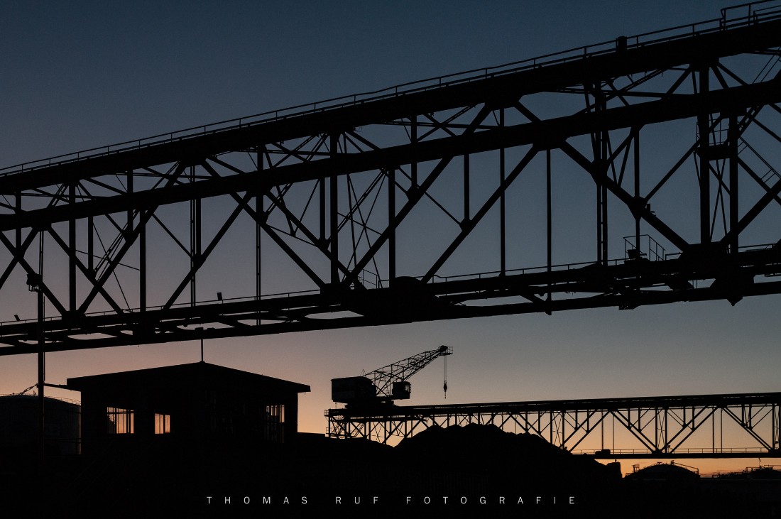 Industrielle Silhouetten: Kräne im Basler Rheinhafen bei Birsfelden in der blauen Stunde